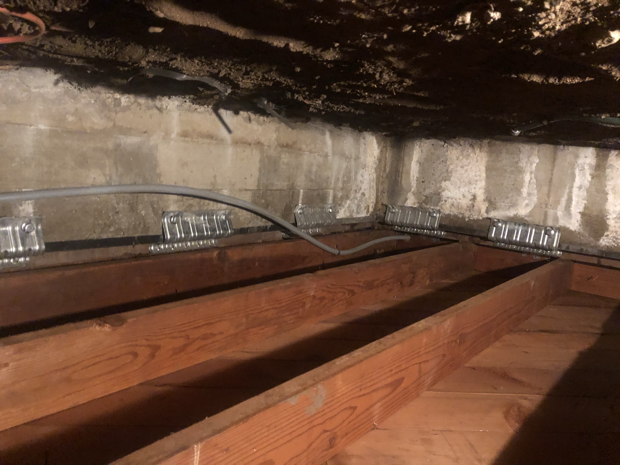 Seismic foundation hold-downs and anchors installed under a house